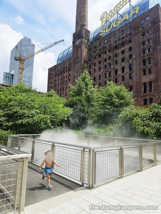 Fog rising along the waterfront path, the old refinery behind.
